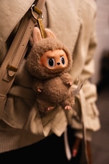 A plush toy keychain hangs from a purse.