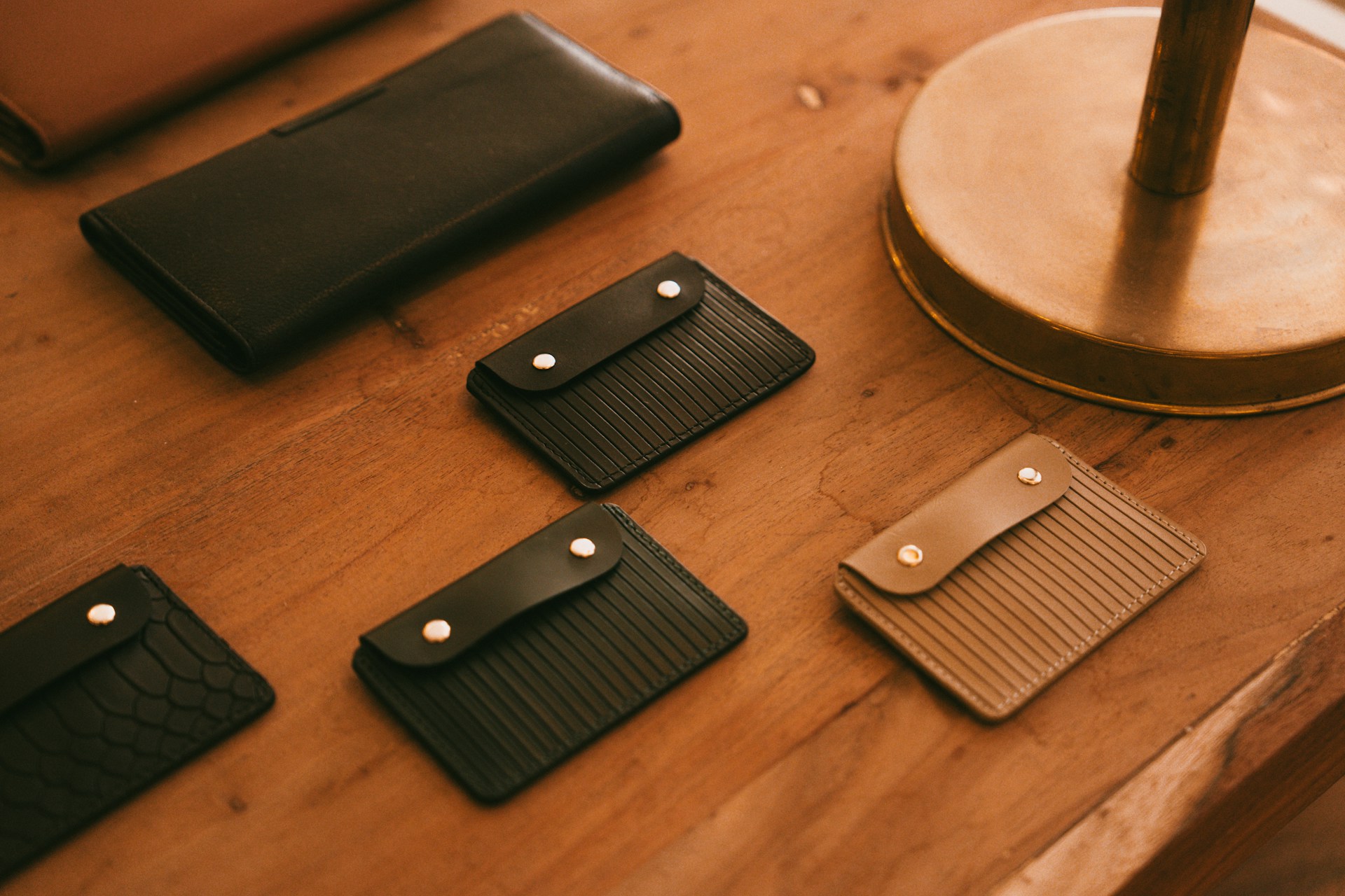 Leather wallets and cardholders sit on a table.