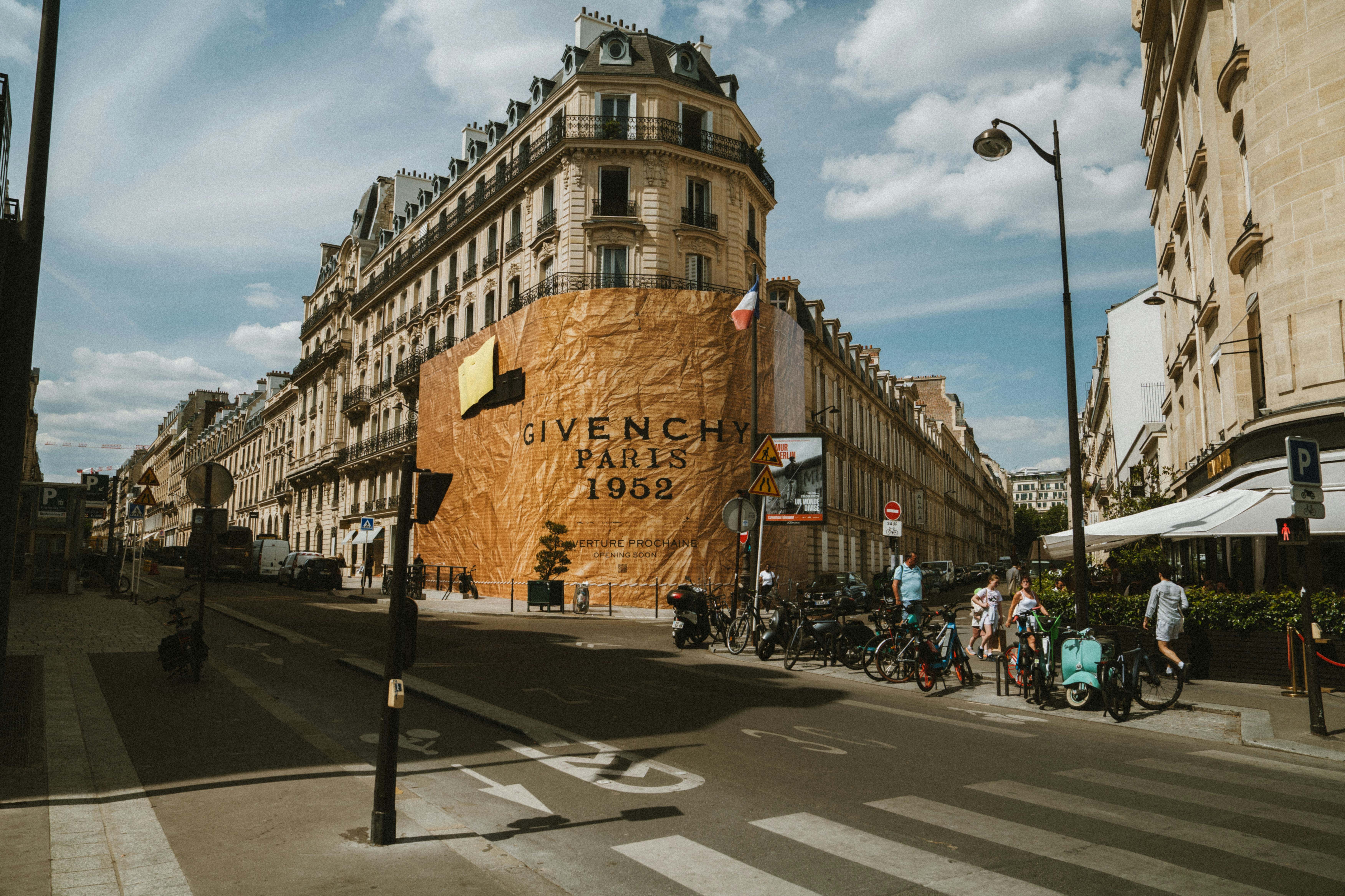 A building in paris is covered in givenchy branding., 