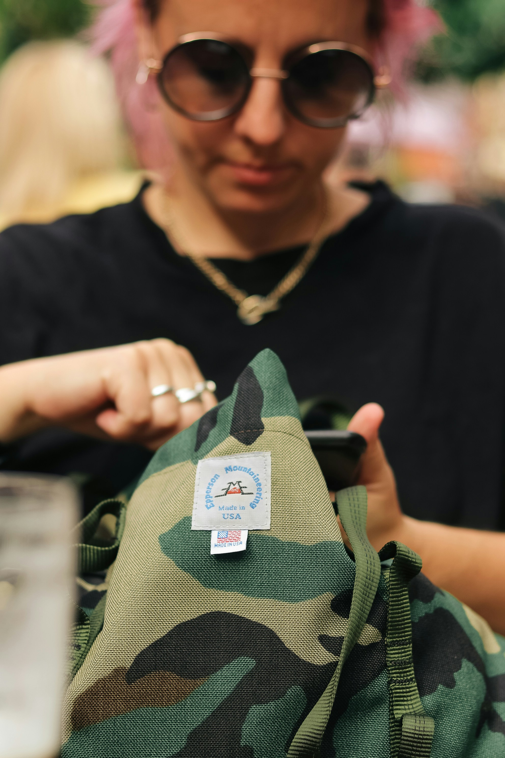 Woman inspecting a camouflage backpack.