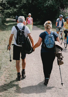 Couple holds hands while walking down a path