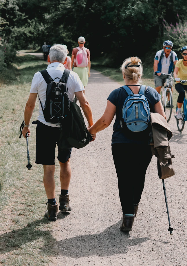 Couple holds hands while walking down a path