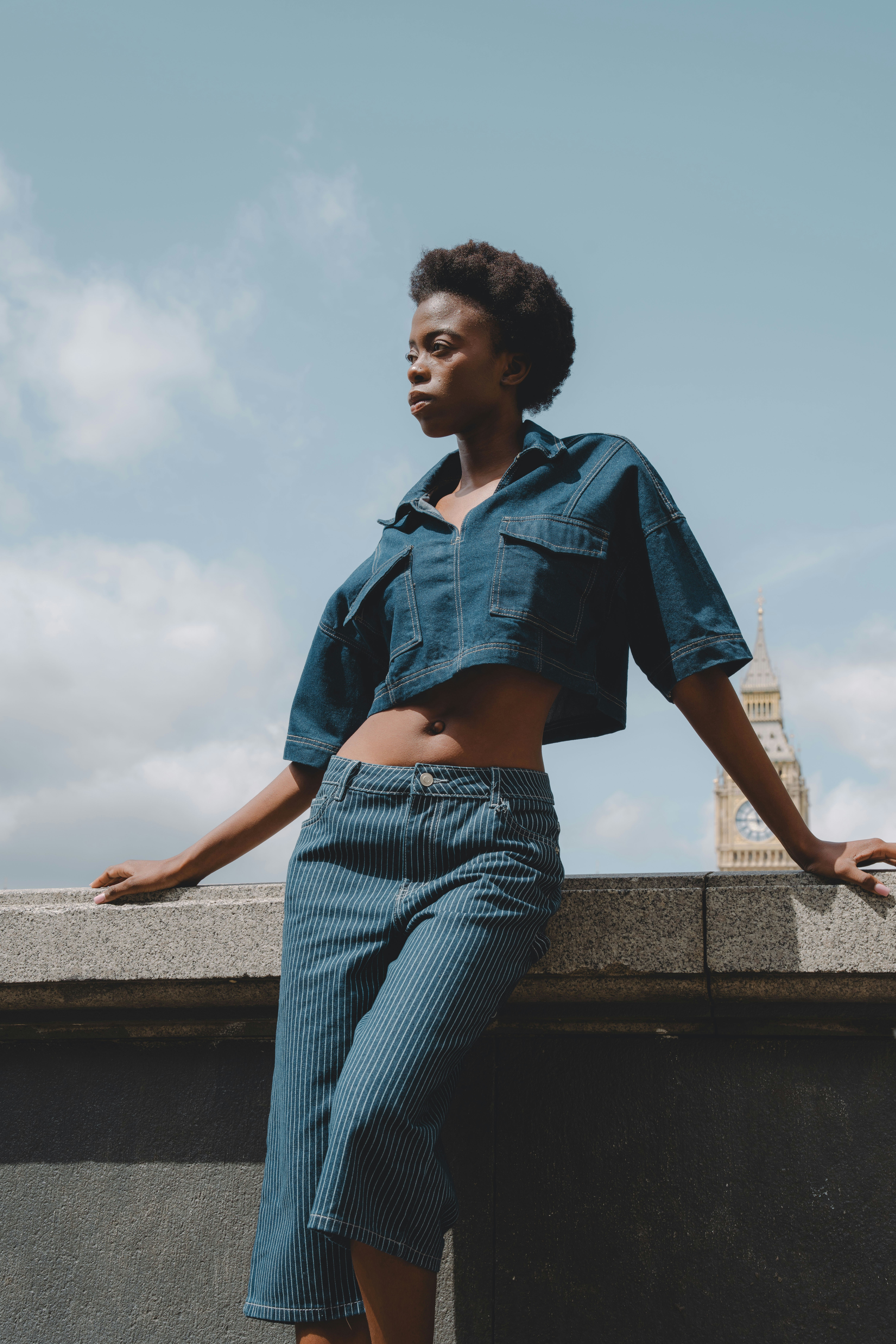 A woman poses in denim against big ben.