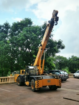 A yellow crane is parked on a paved surface.
