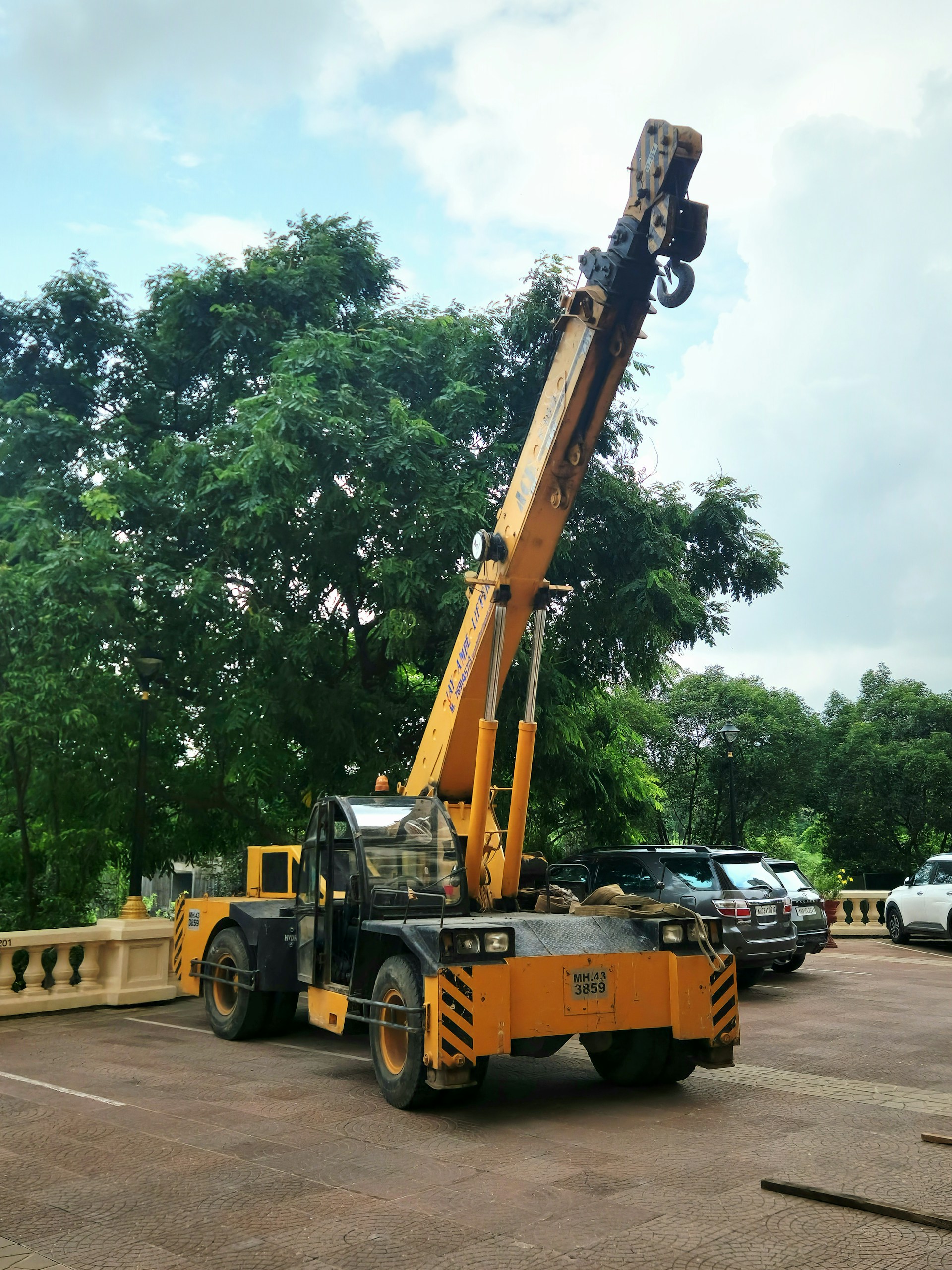 A yellow crane is parked on a paved surface.
