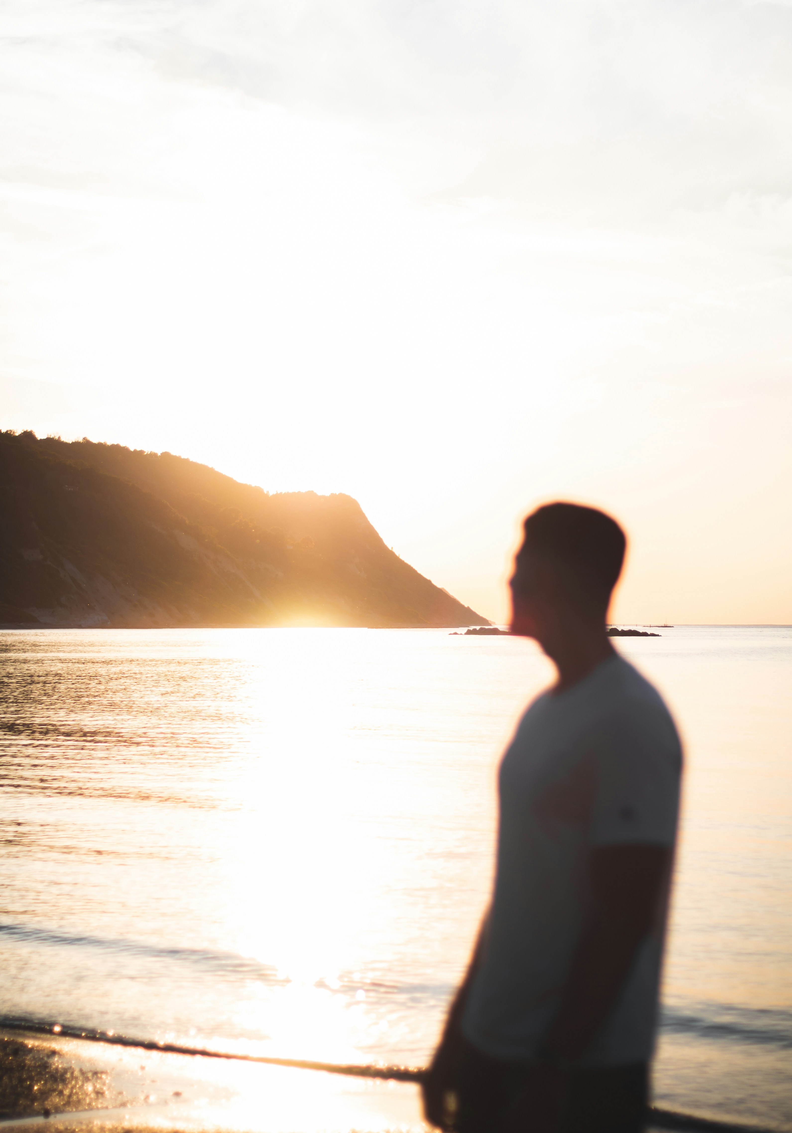 Man stands at the beach during a beautiful sunset.