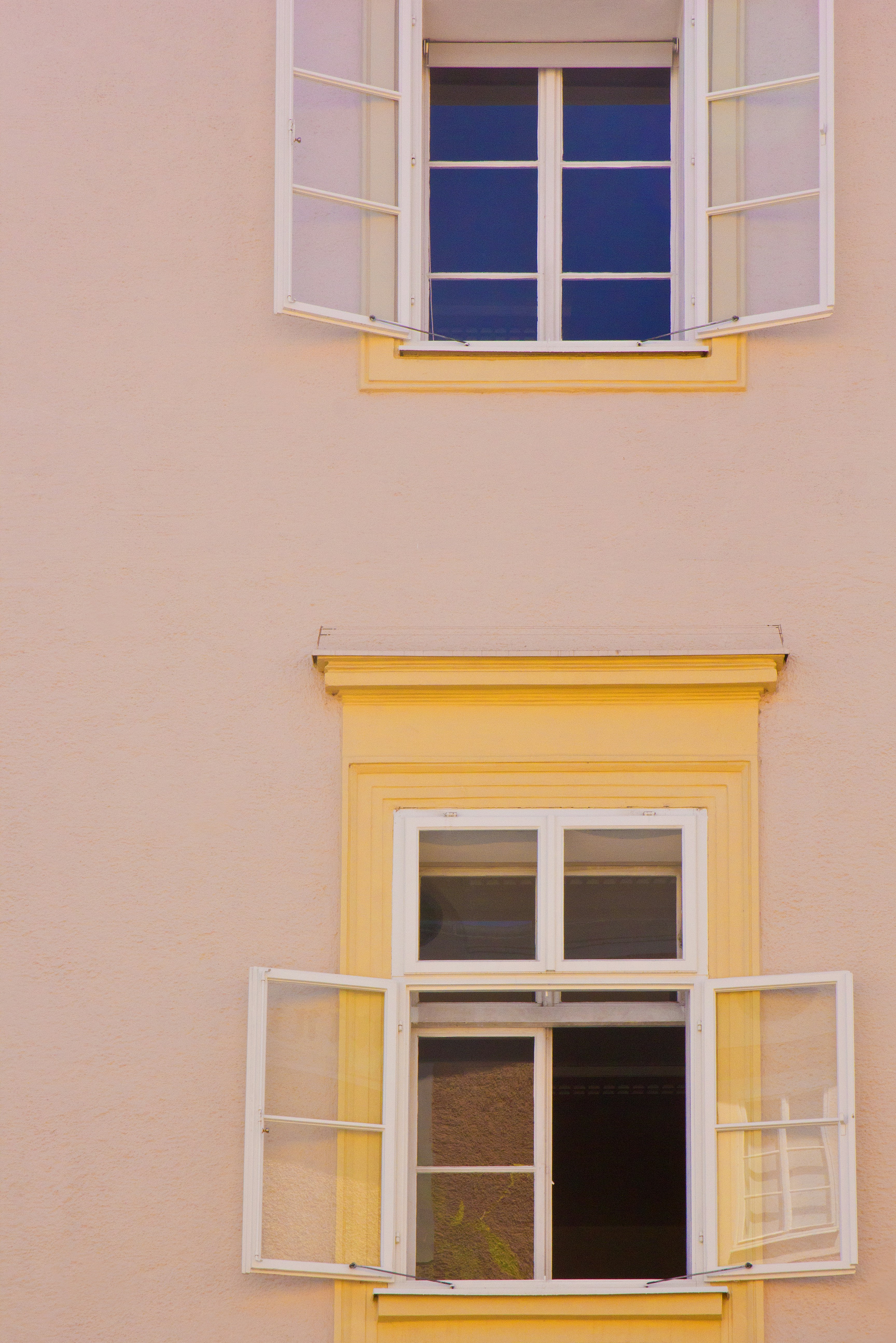 Two windows on a pale pink wall.