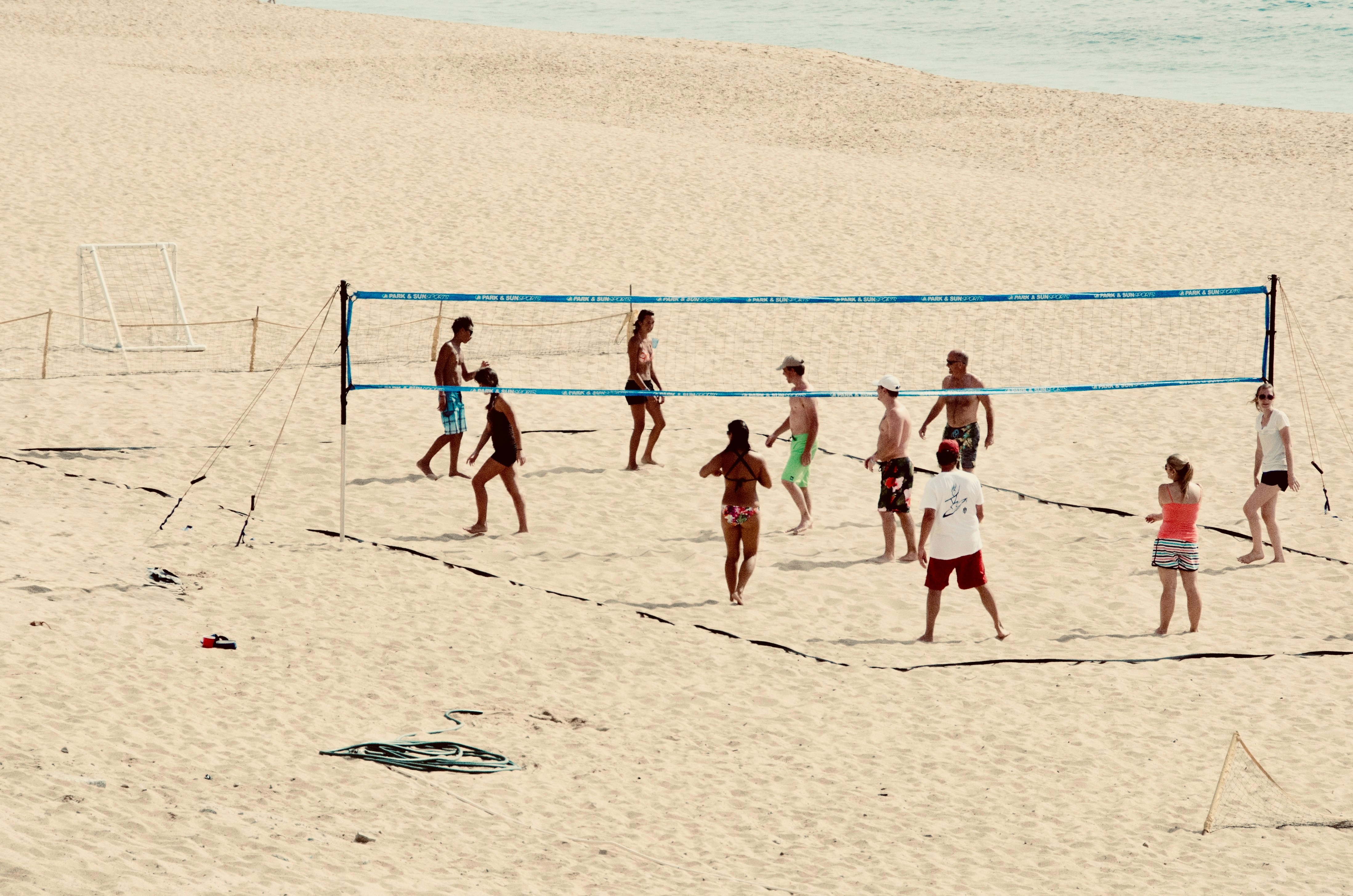 La gente gioca a beach volley sulla sabbia.