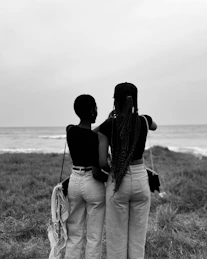 Two friends stare out at the ocean together.