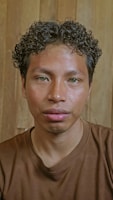 A man with curly hair stares at the camera.