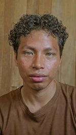 A man with curly hair stares at the camera.