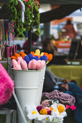 Handmade crochet flowers are displayed at a market.