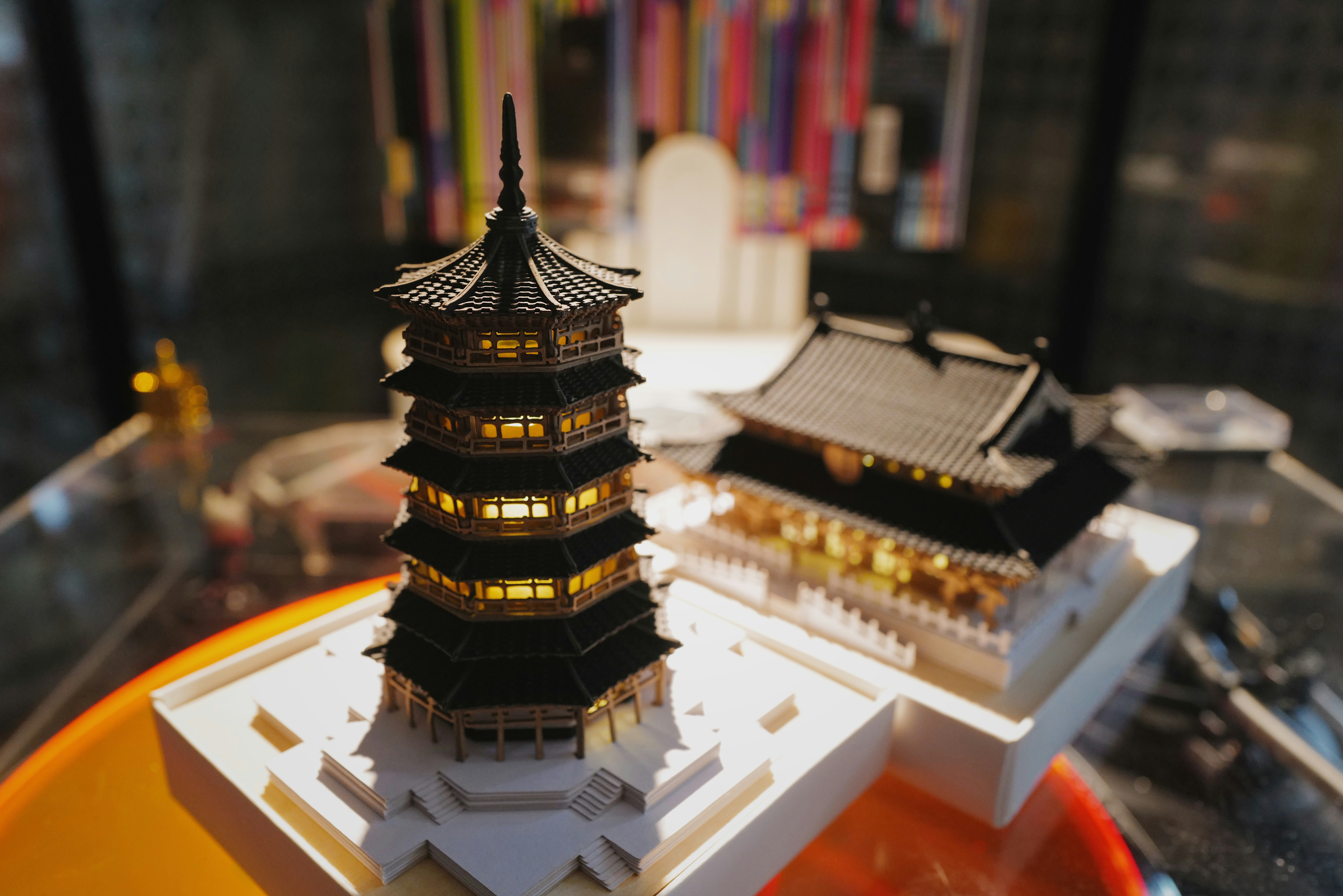 Miniature japanese pagodas are displayed in a cabinet.