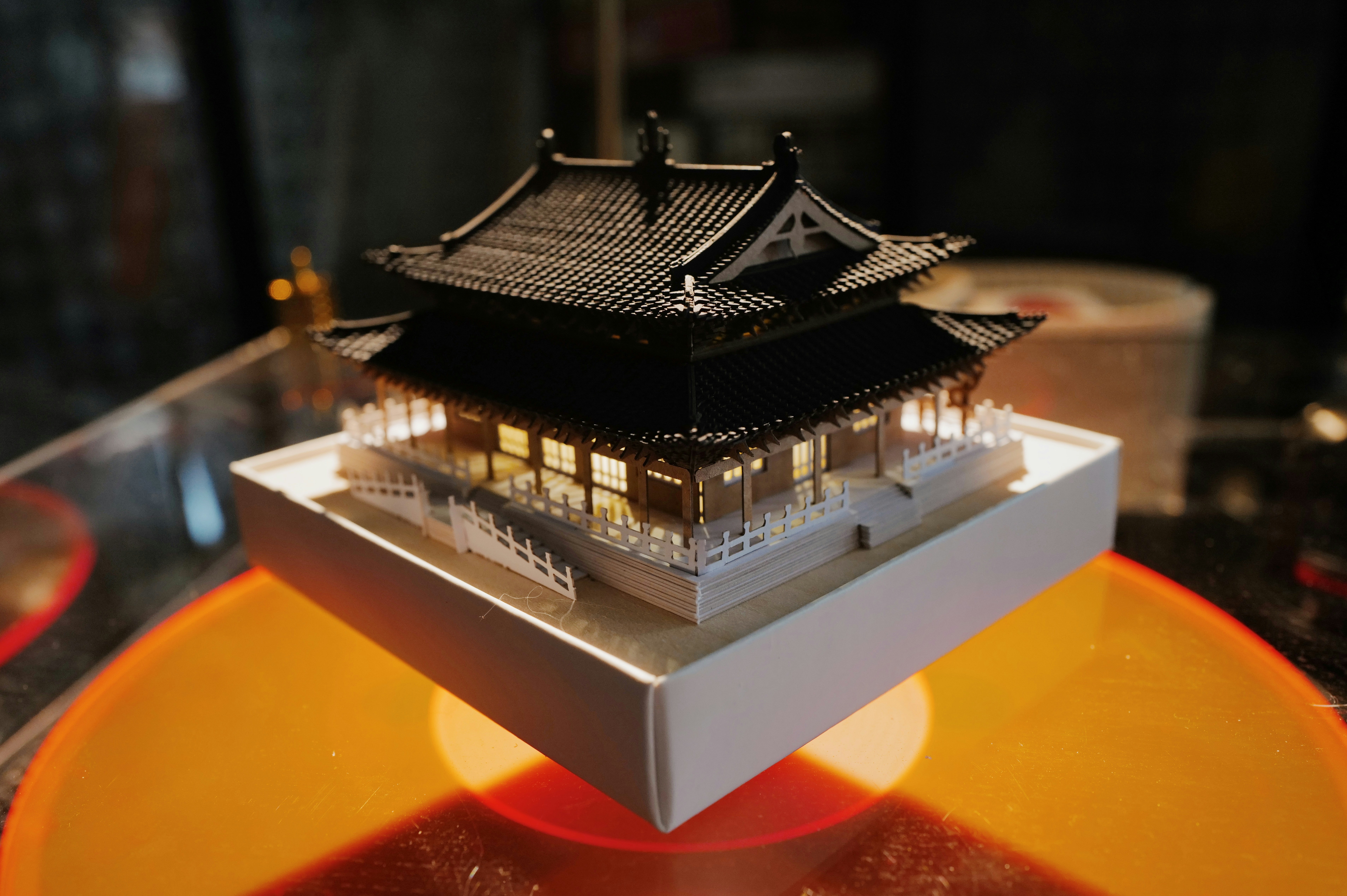 A miniature pagoda rests on a vinyl record.