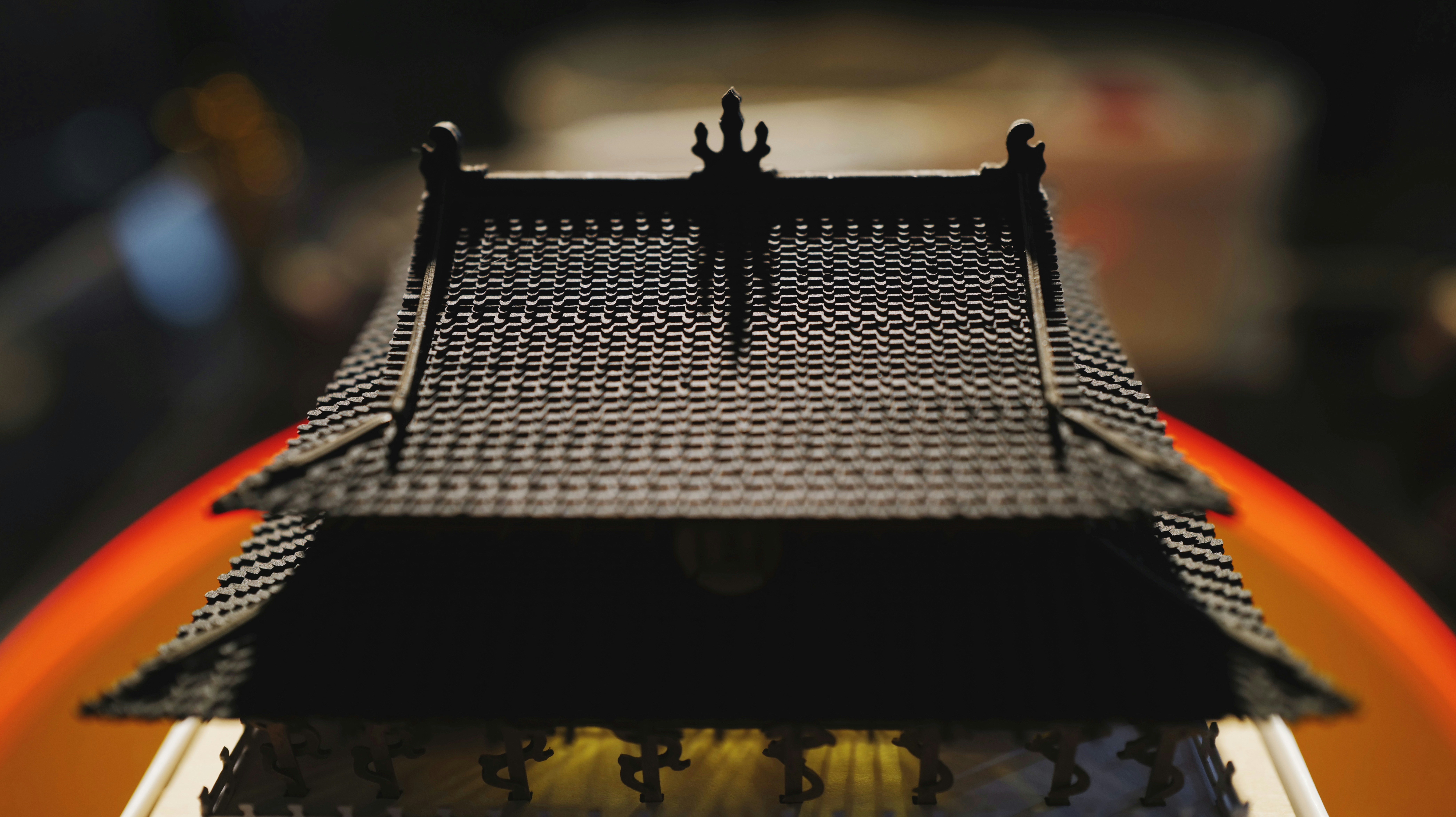 A miniature roof model is lit in shadow.