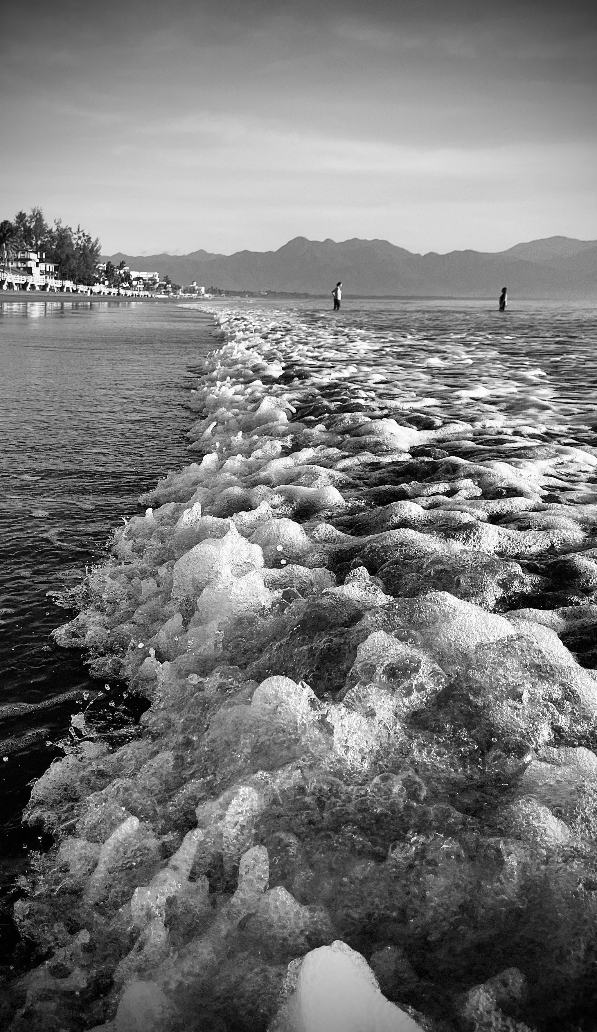 Foaming waves crash on a beach.