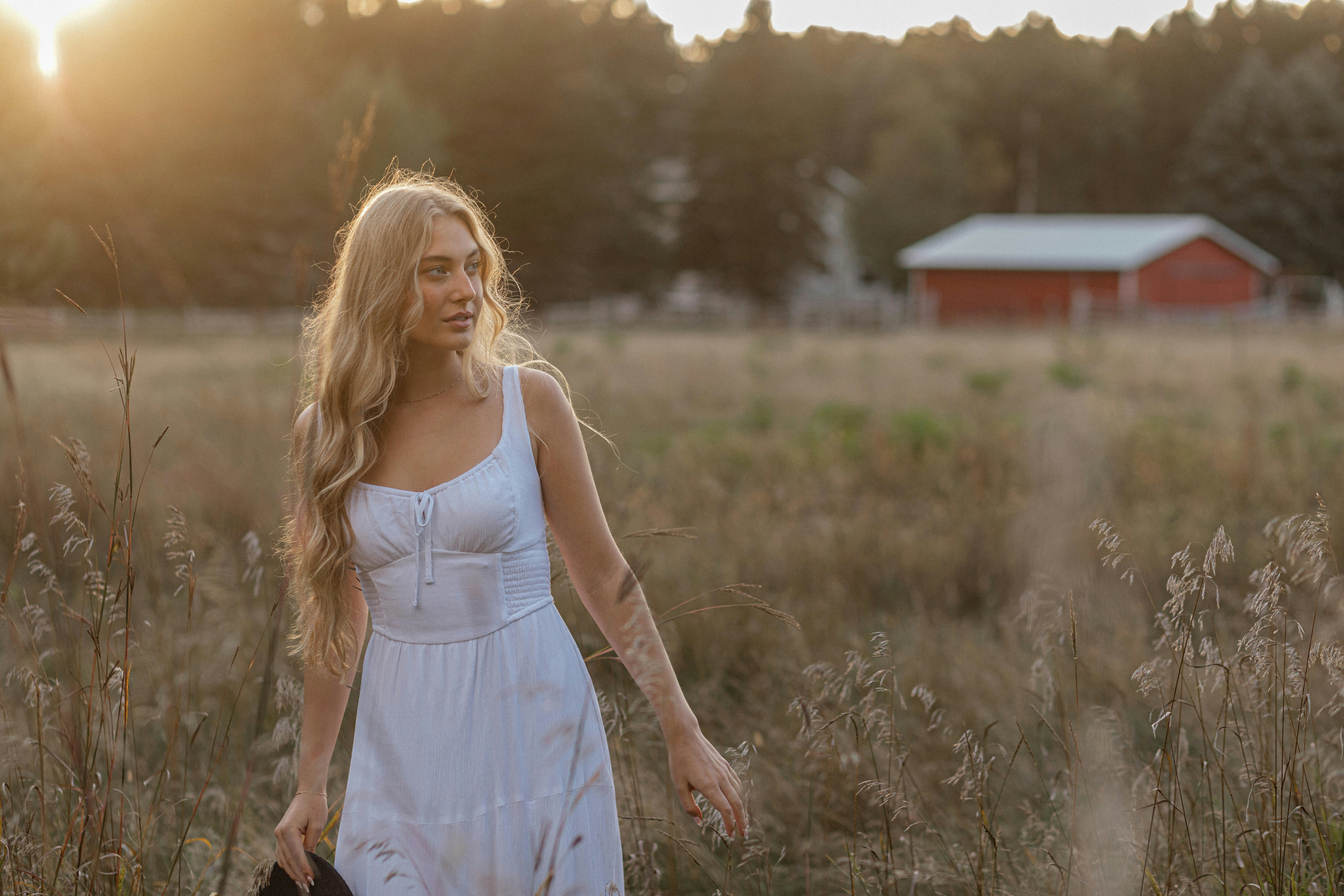 Woman in a field poses during golden hour.