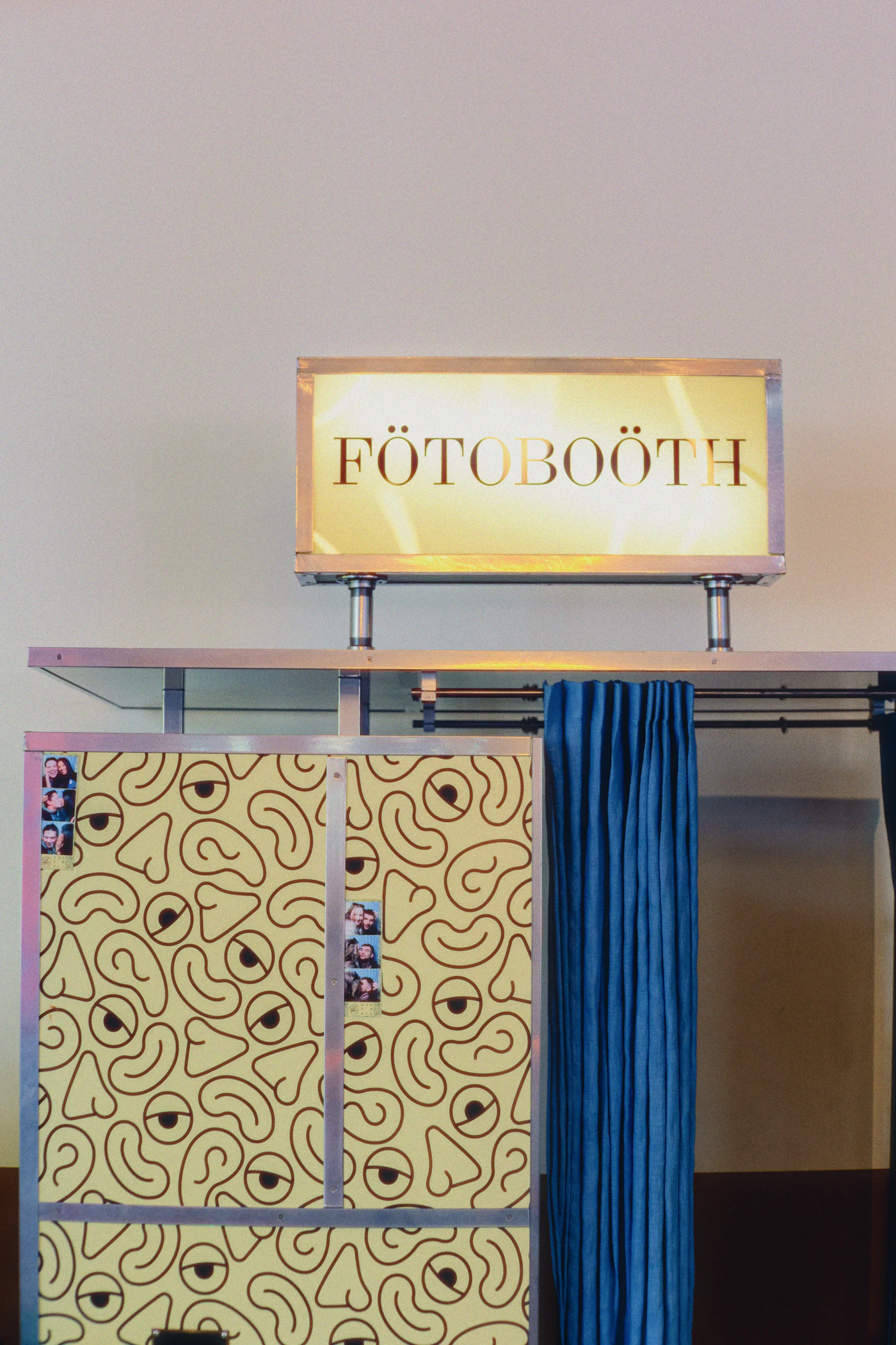 DIY photo booth backdrop for receptions — A DIY photo booth backdrop with hanging streamers and festive props.