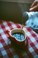 Coffee is being poured into a heart-shaped mug.