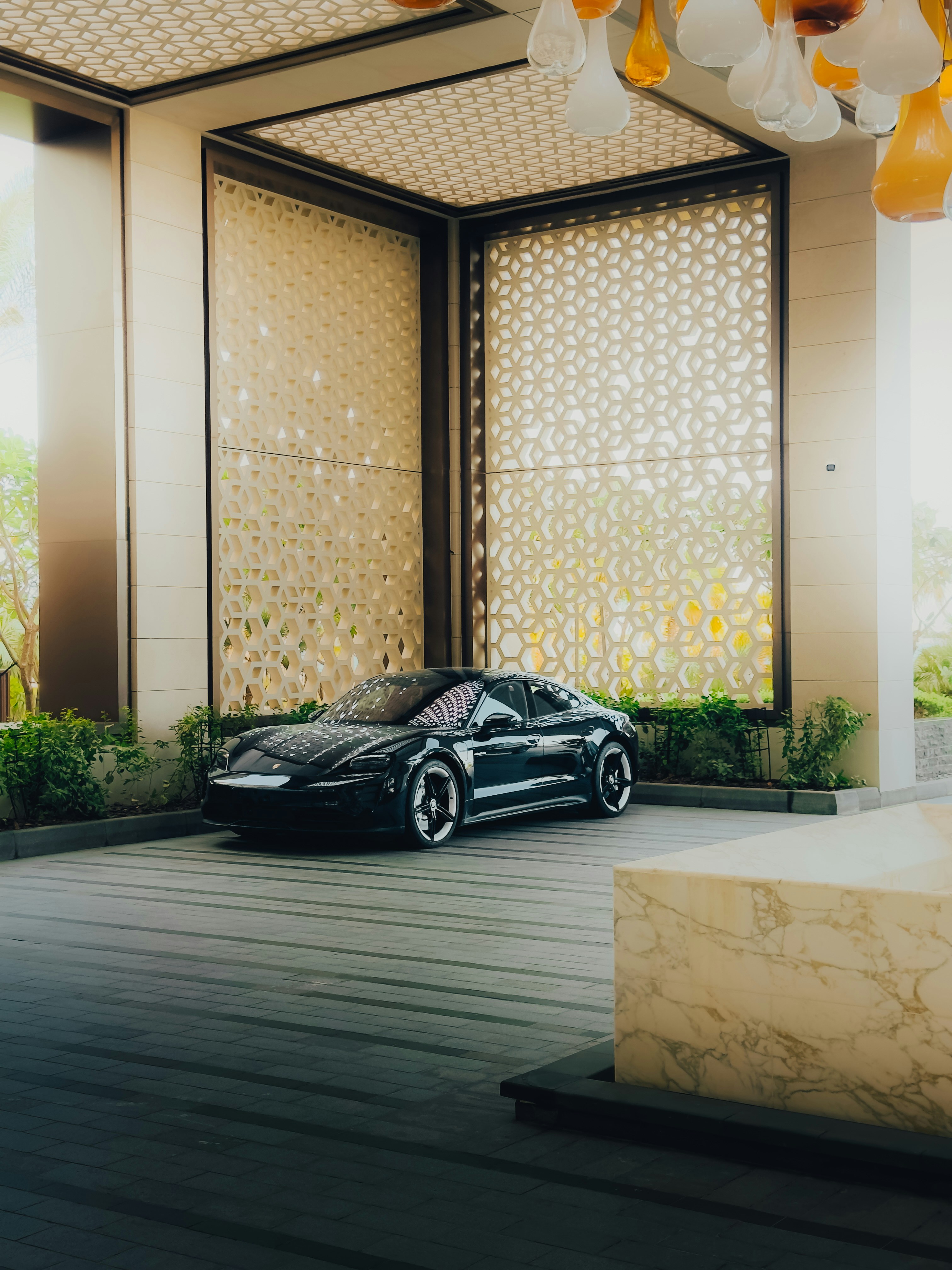 A luxury car is parked in an elegant entryway.
