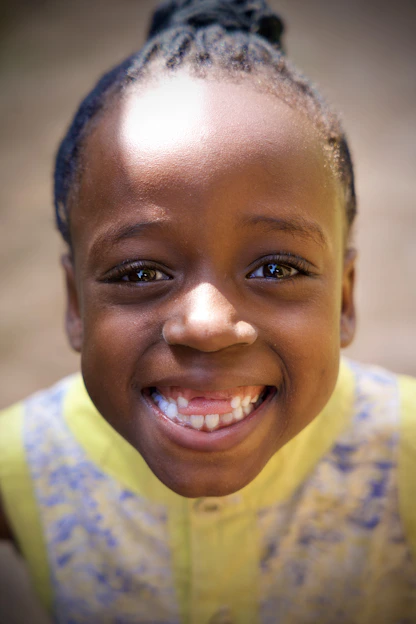 A happy young girl smiles brightly at the camera.