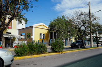 A yellow building stands near green trees.