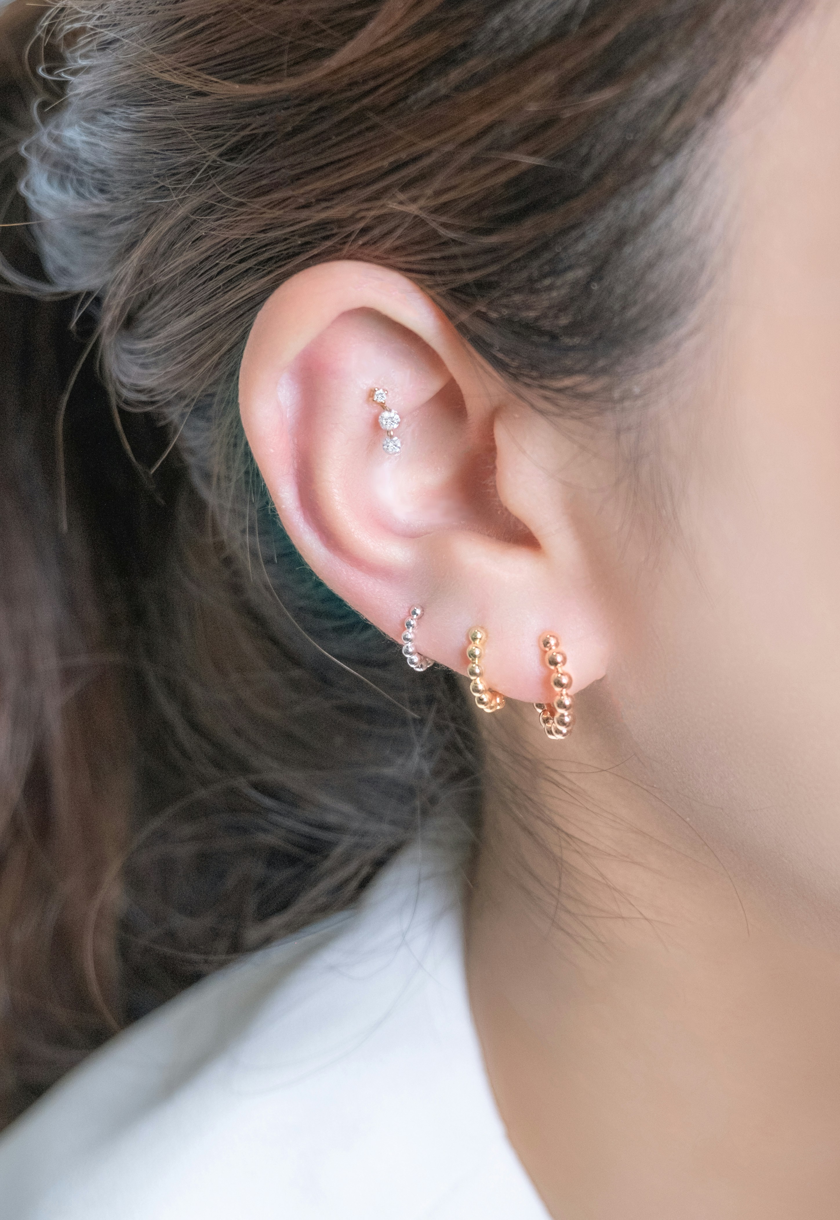 Earrings adorn a woman's ear.