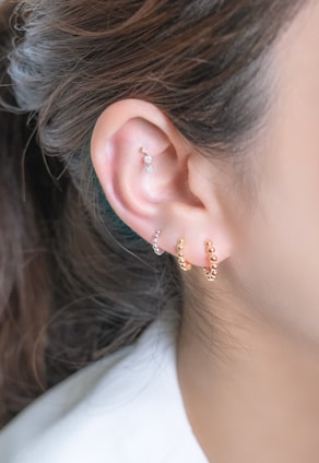 Earrings adorn a woman's ear.