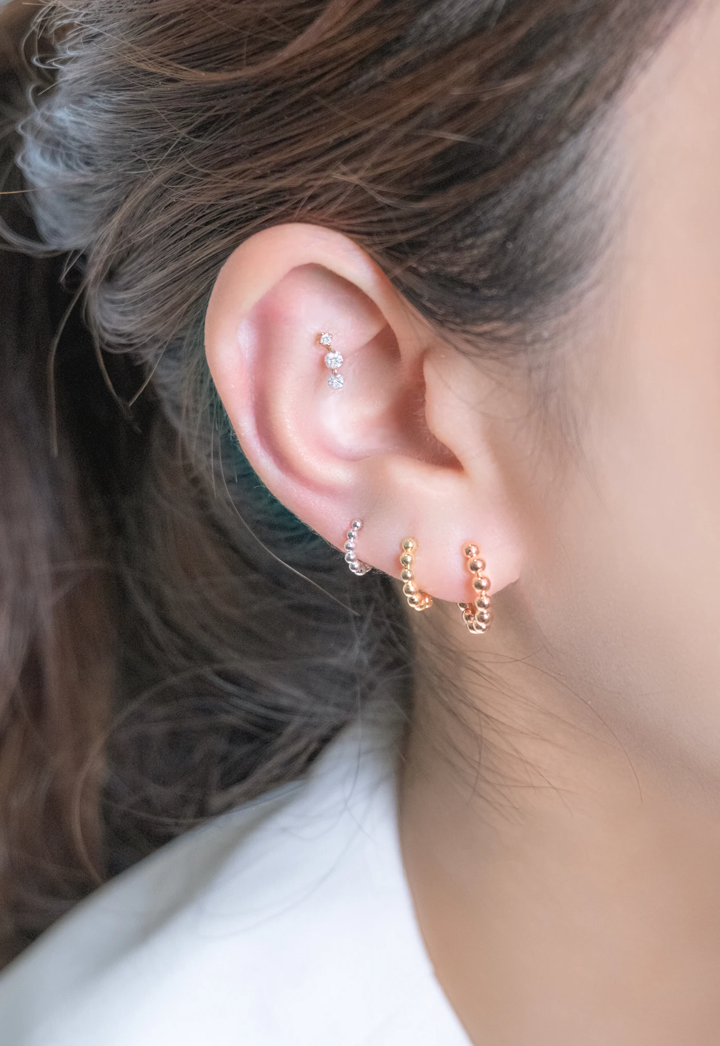 Orelha com vários piercings e joias