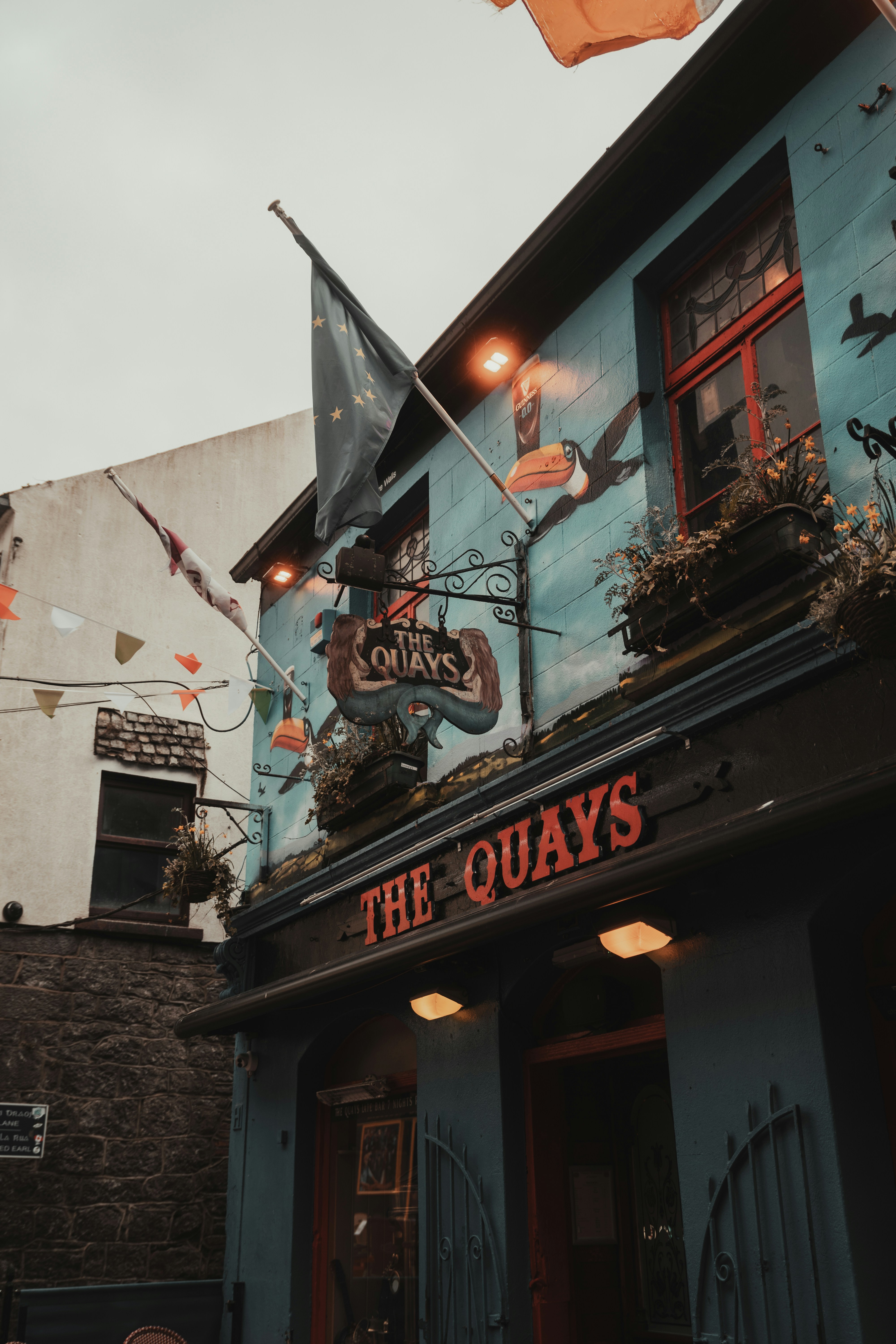 The quays pub is seen on a street corner.