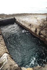 Water fills a rectangular, stone-lined structure.