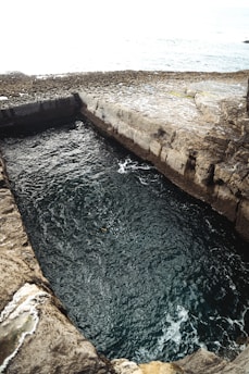 Water fills a rectangular, stone-lined structure.