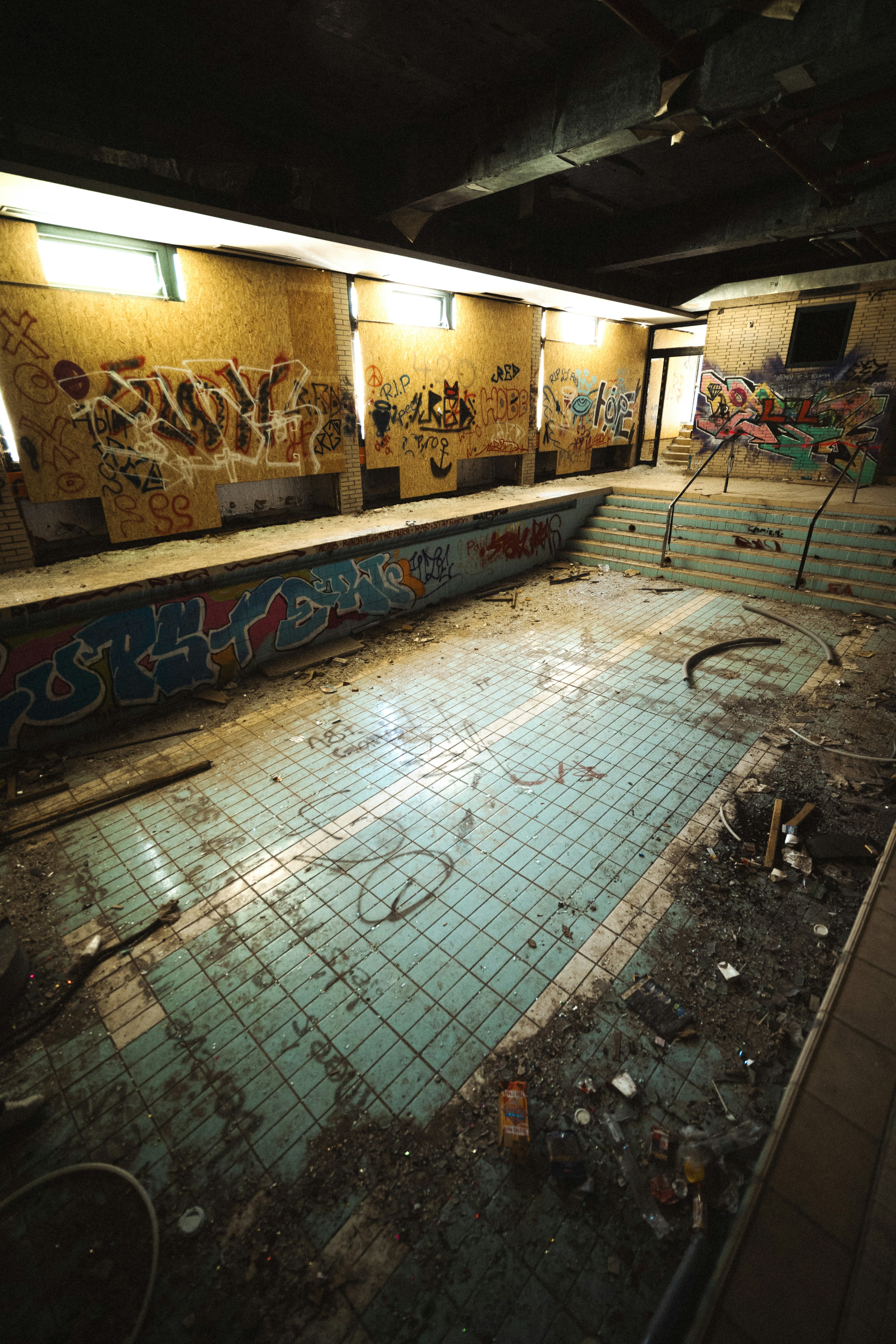 An abandoned swimming pool covered in graffiti.