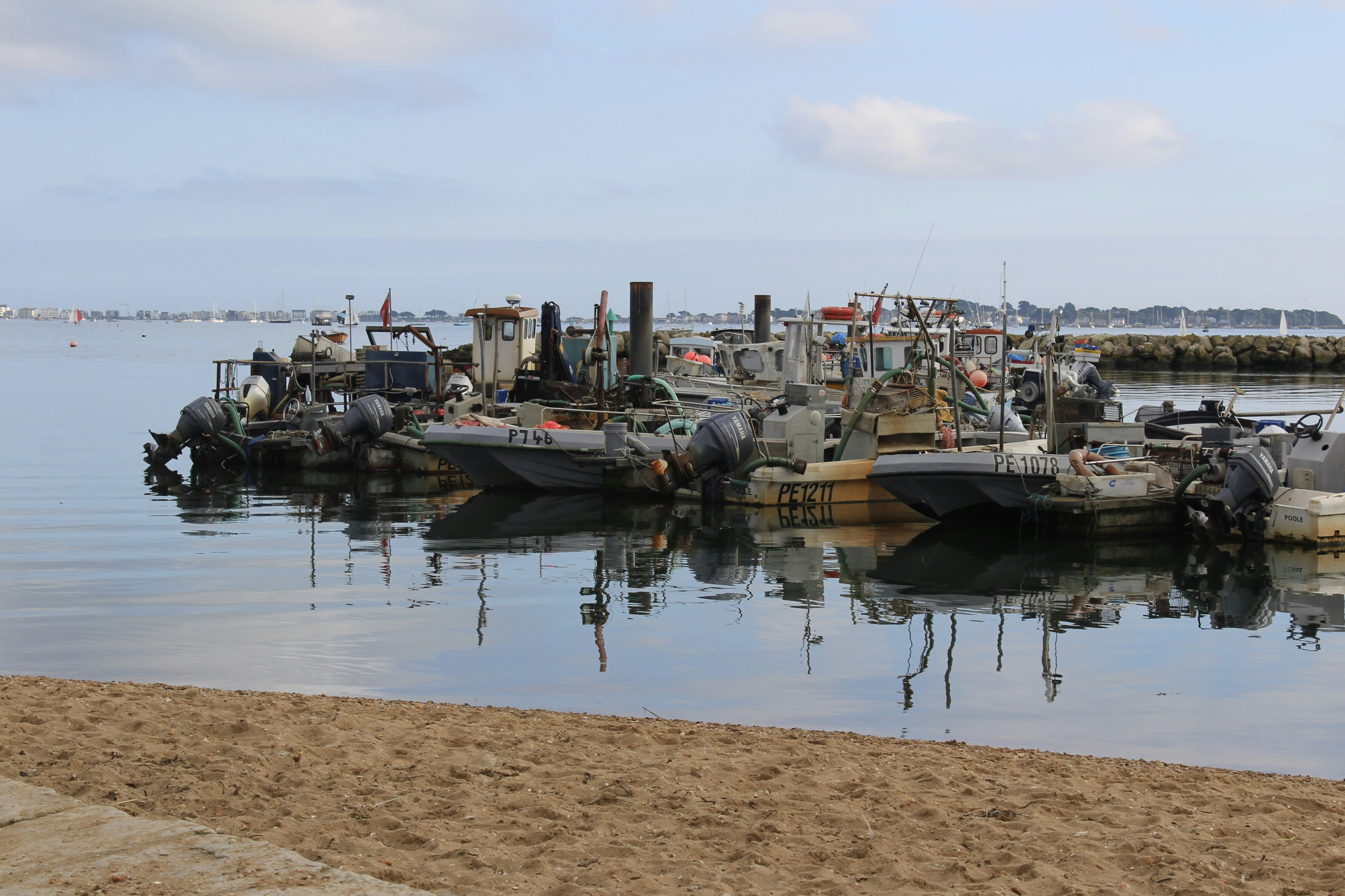 Boats are docked at a calm harbor.