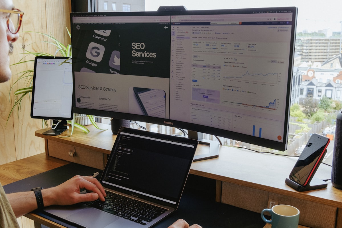 Arbeitsplatz mit Monitoren und Analytics-Dashboard zur SEO-Auswertung