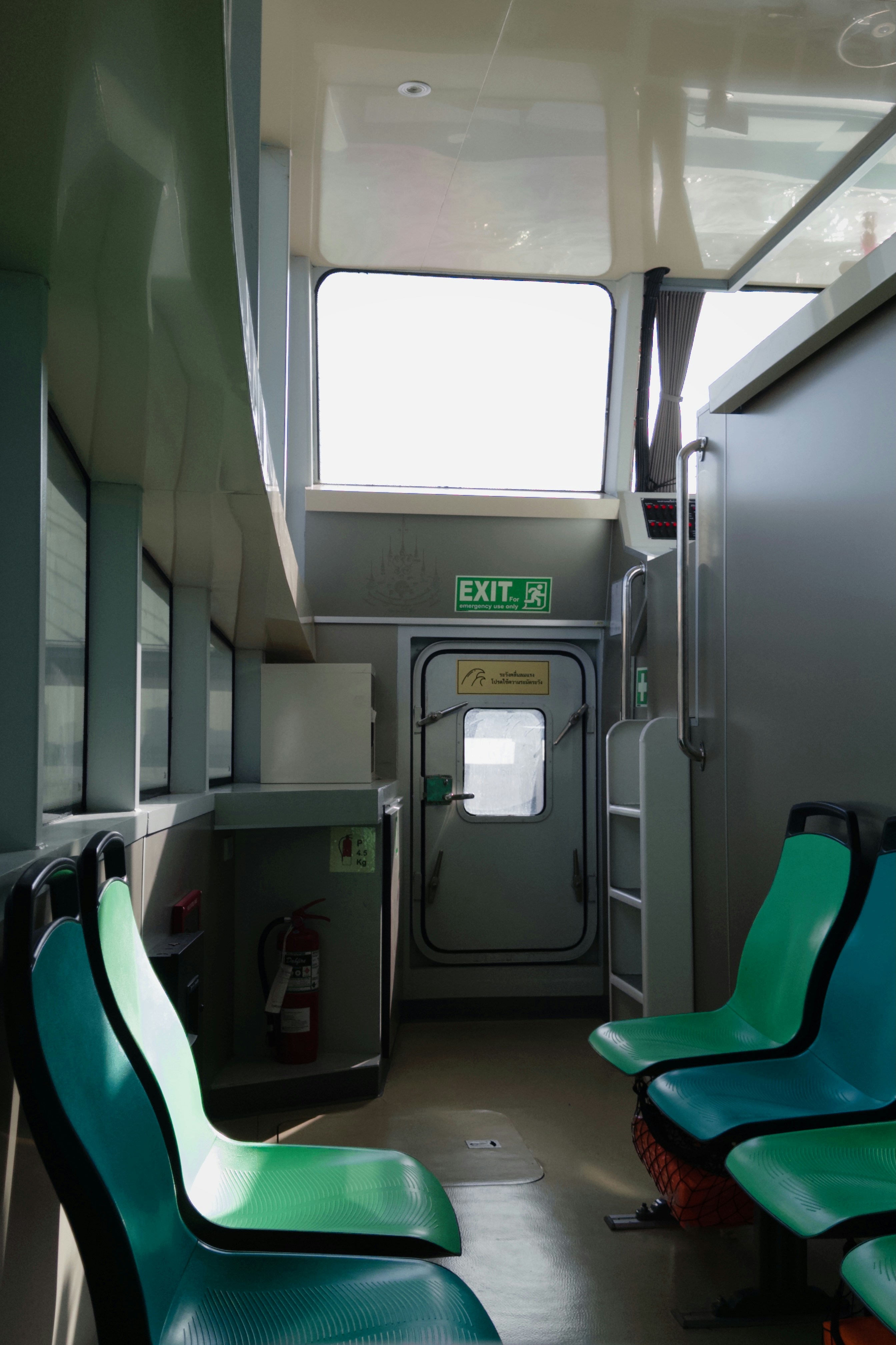 Interior feri penumpang dengan tempat duduk teal.