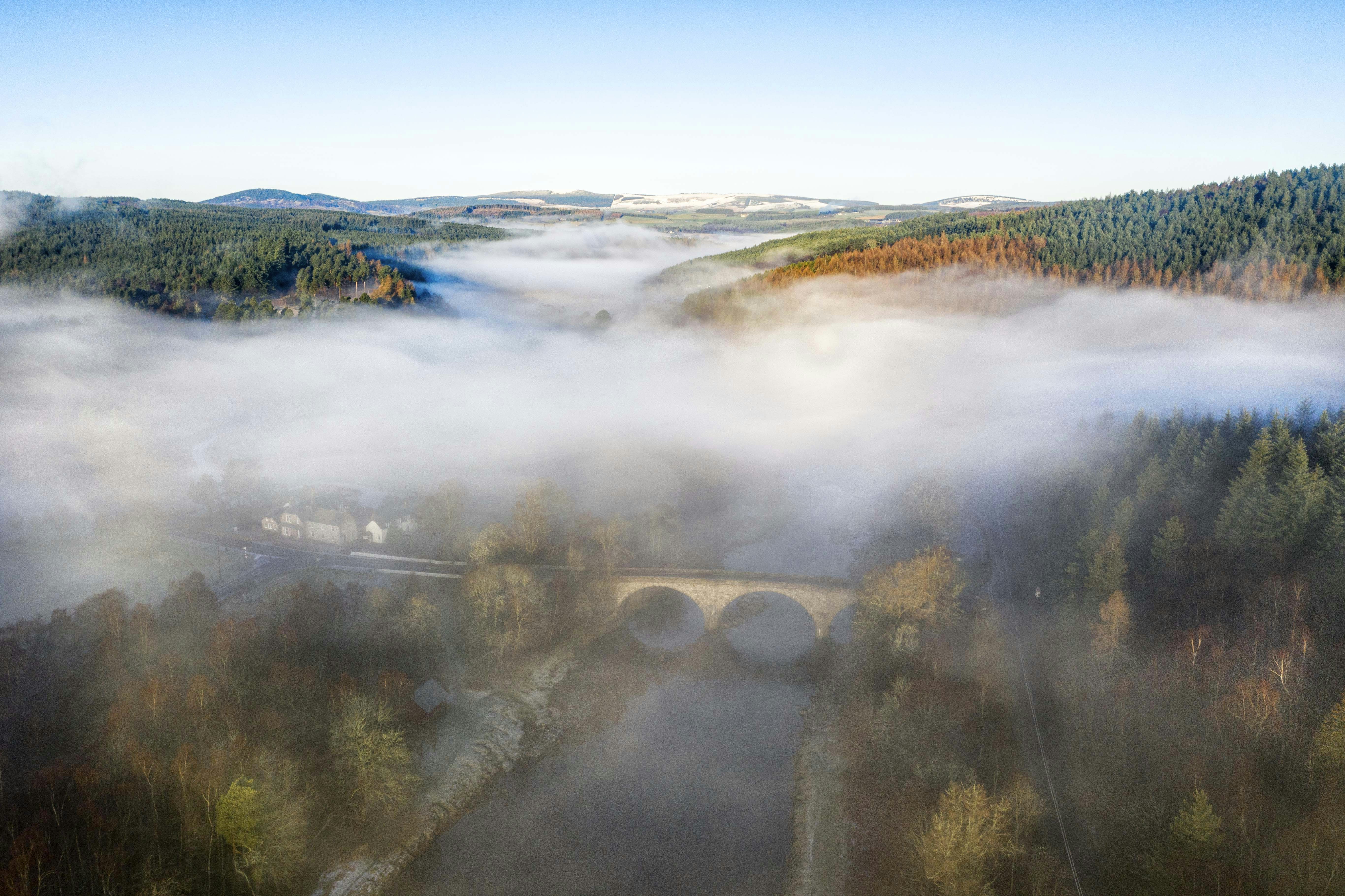 A misty bridge in a beautiful, wooded valley.