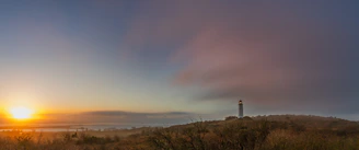 Sunrise with a tower on a hill.