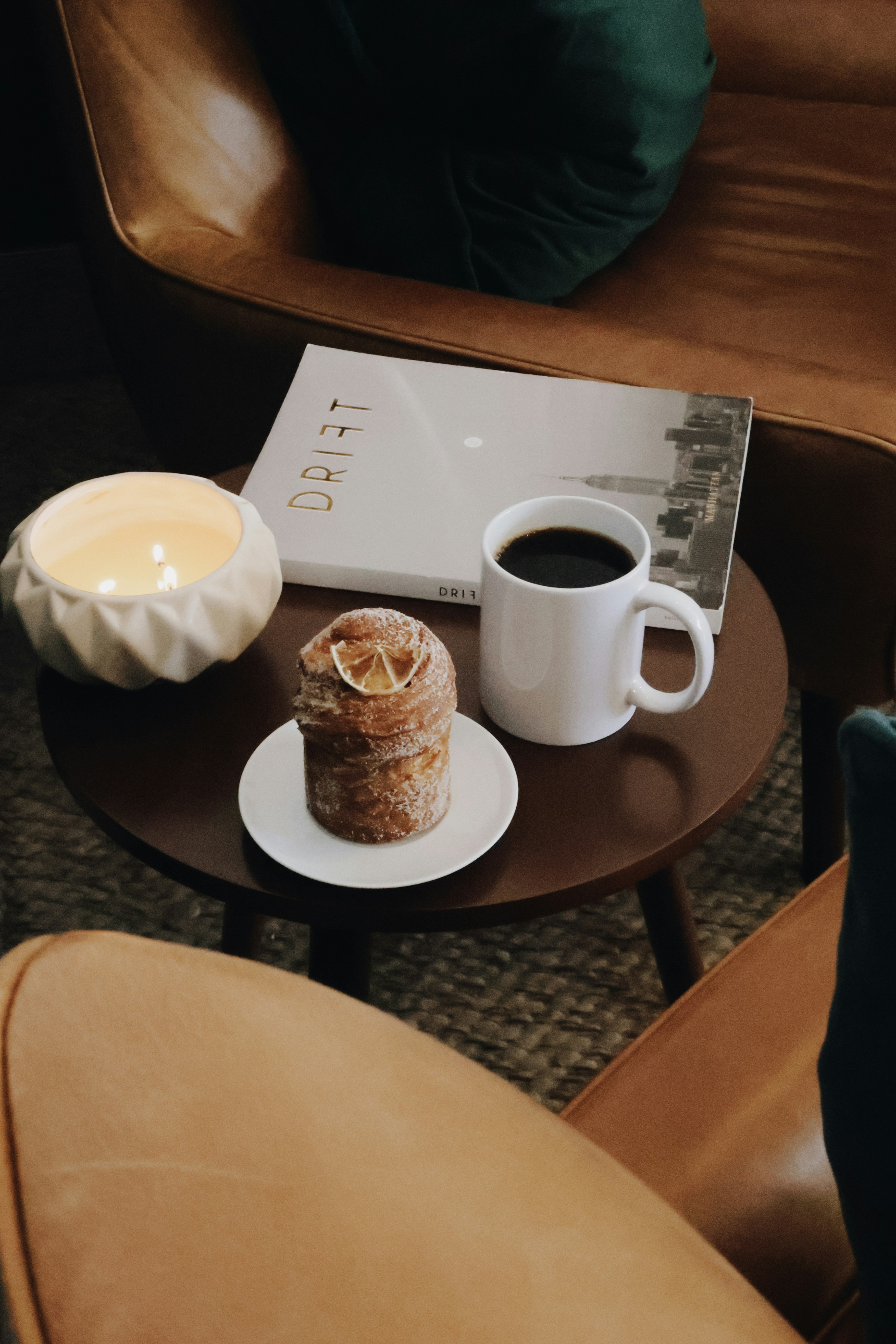 テーブルの上にはコーヒー、ペストリー、雑誌が置かれています。