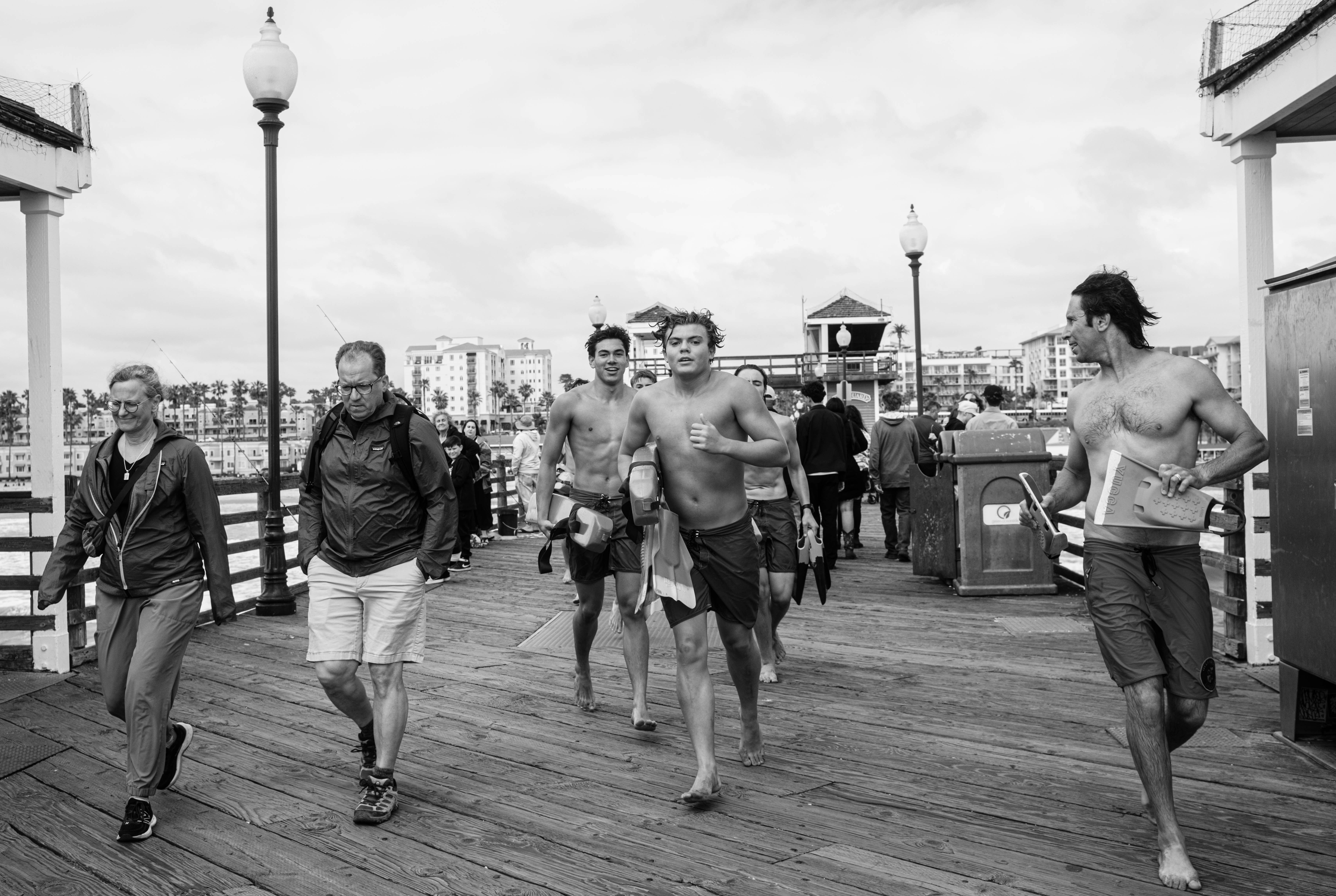 People walk along a wooden pier.