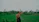 Woman looks at a lush green field with a hand on her head.