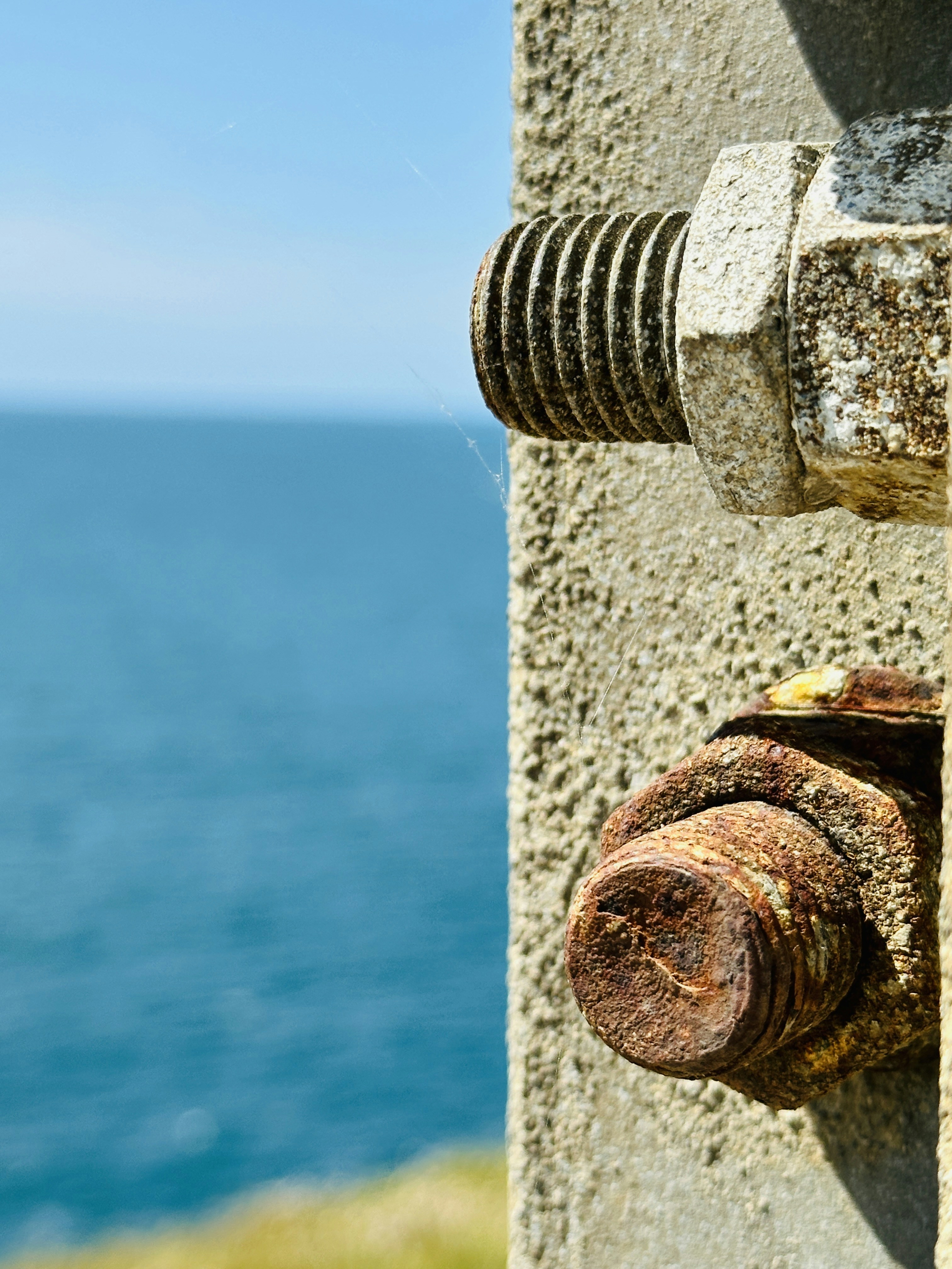 Rusty bolts and a blue sea.