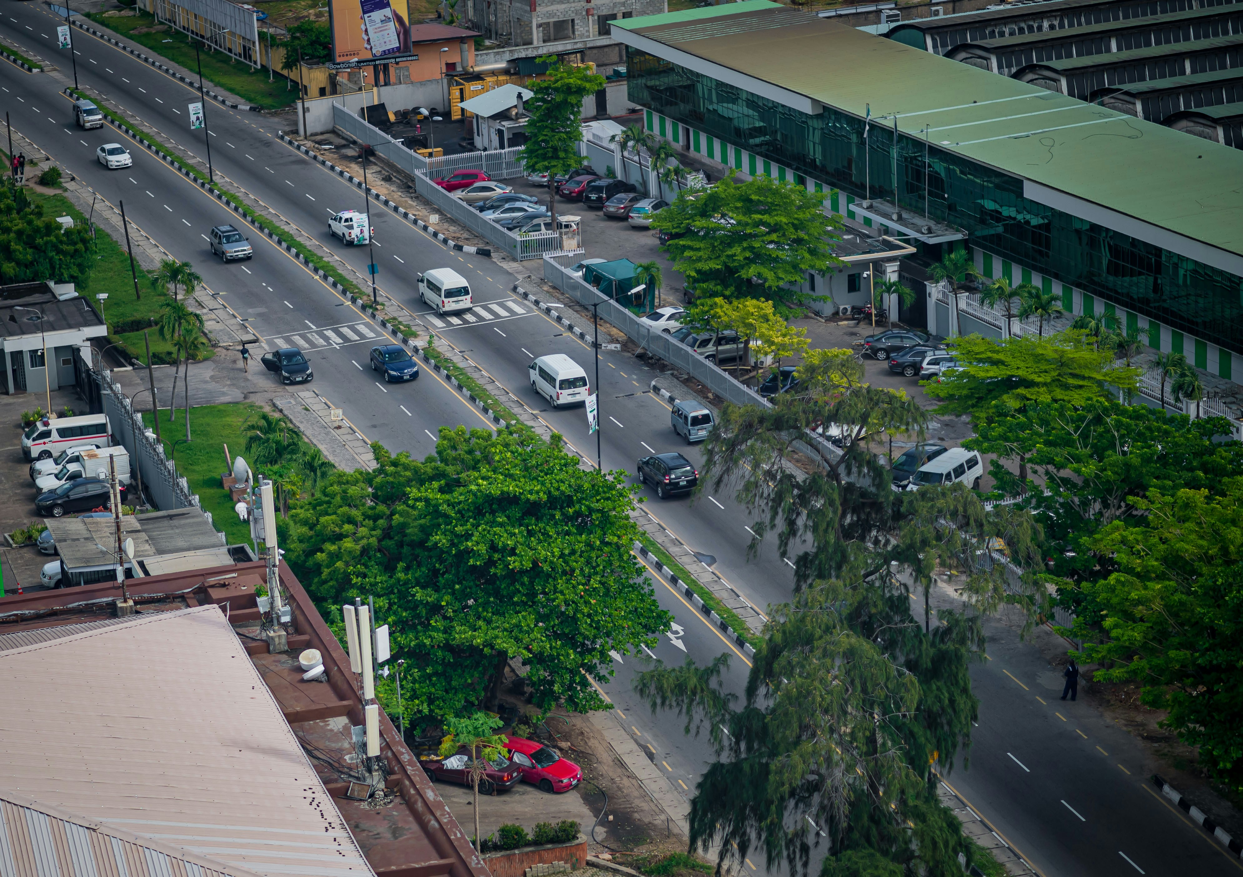A road with cars runs through a city.