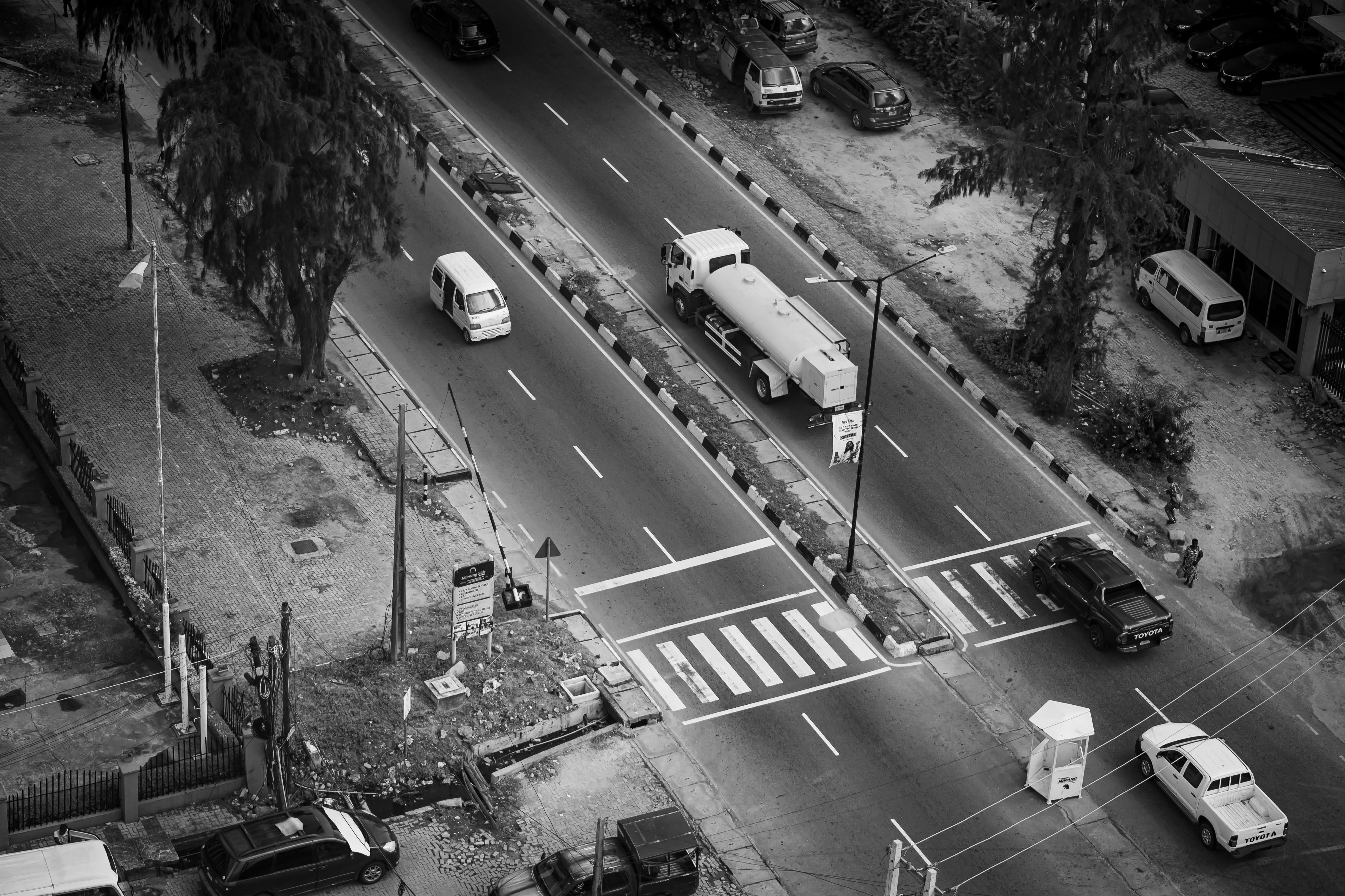 Cars are driving on a black and white road.