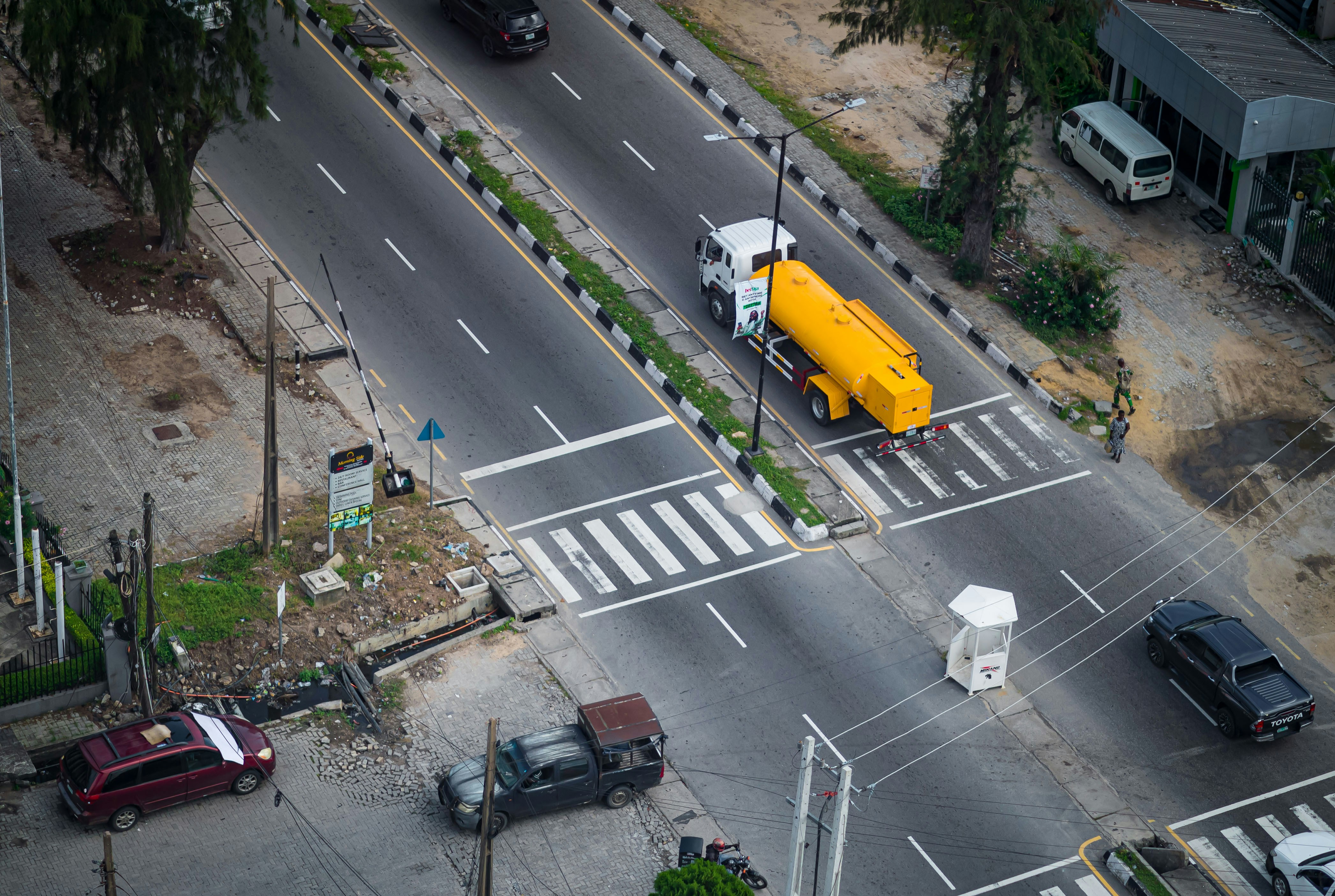 Vehicles drive on a road with a tanker truck.