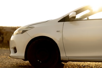 A white car is illuminated by sunlight.