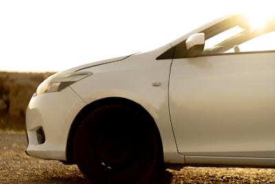 A white car is illuminated by sunlight.