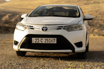 A white toyota car is parked outdoors.