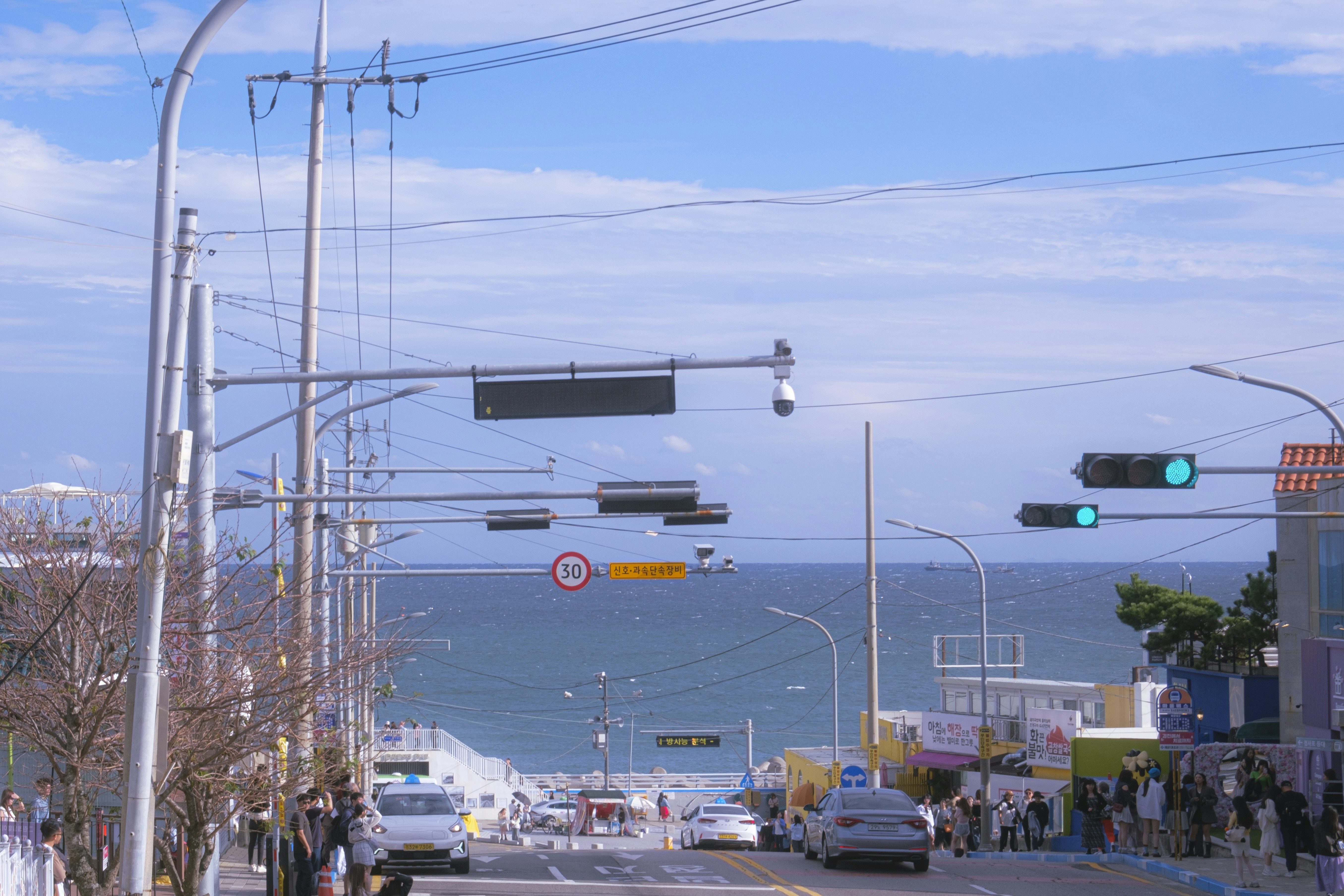 Street leads to the ocean under a clear sky.
