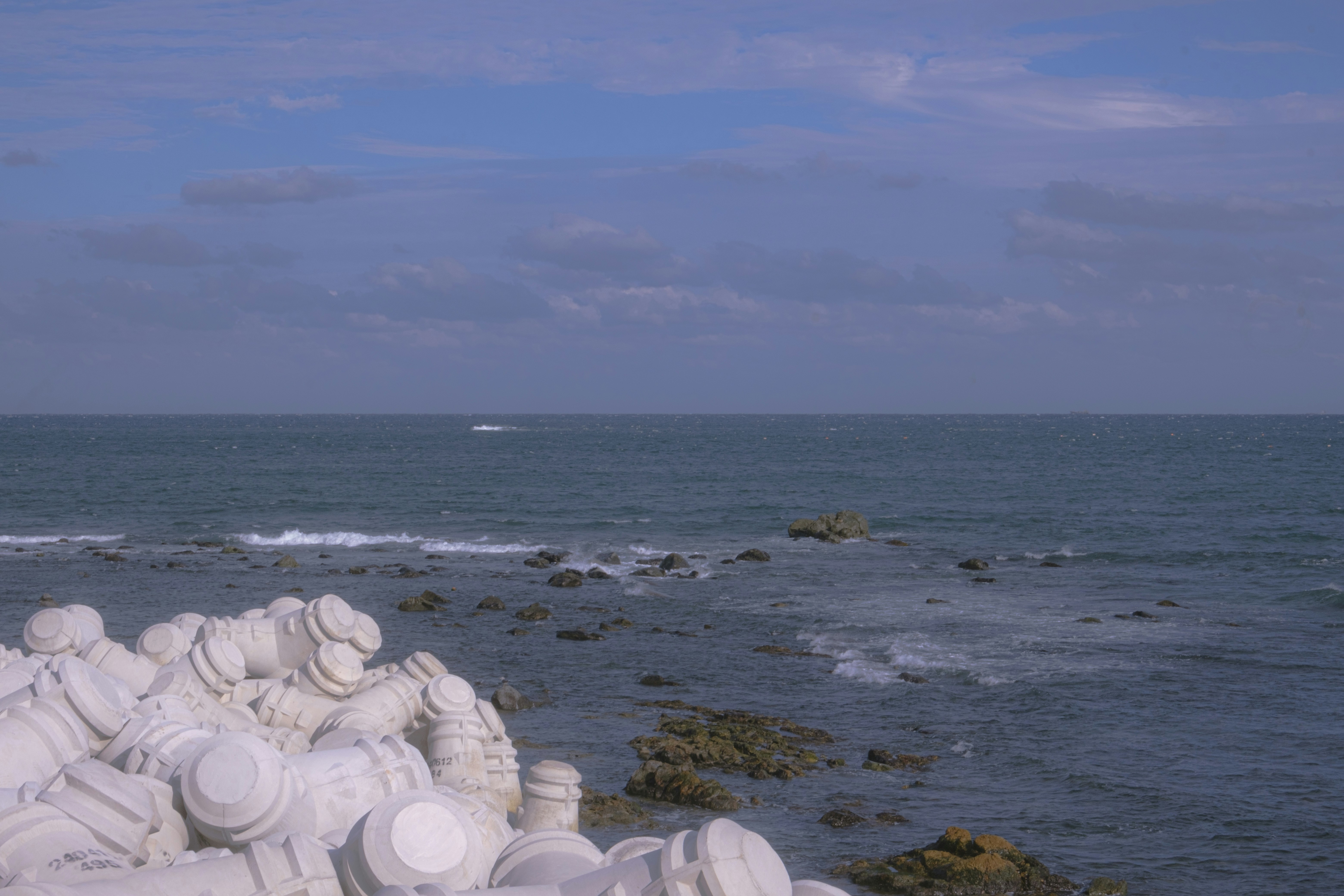 The calm ocean meets the rocky shore.